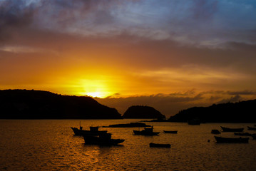 Sunrise at Tartaruga beach in Buzios, calm sea and several fishing boats, Rio de Janeiro state, Brazil