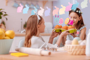Obraz na płótnie Canvas Careful little female taking plate with cakes