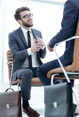 Two businessmen holding briefcases near themselves