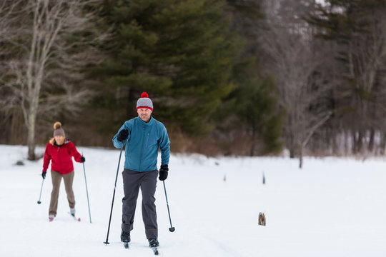 A man and woman cross country skiing on a frozen pond in Epping, New Hampshire.