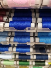 reels with colored threads on the shelf