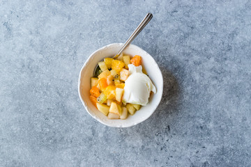 Fruit Salad with Vanilla Ice Cream in Ceramic Bowl.