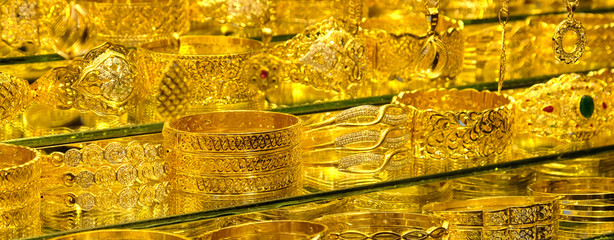 Gold jewelery - rings and bracelets on the showcase of a jewelry store