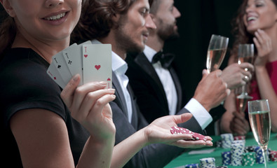 Portrait of the female gambler at the poker table with cards