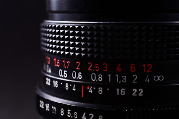 Vintage lens scale signs closeup. Stock photo with blurred gray background.