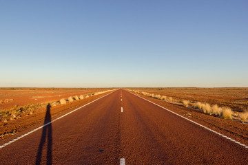 Fototapeta na wymiar red straight road with red dessert on the Stuart Highway north of copper pedy, South Australia,