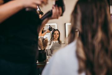 Beautiful brunette woman with long hair at the beauty salon getting a hair blowing. Hair salon...