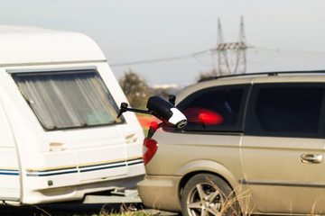 Flying drone close to car with caravan
