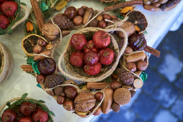 Dry red pomegranate fruit in wicker basket on table