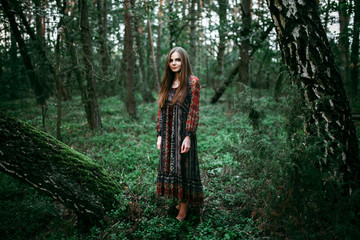 woman stands in the middle of the forest
