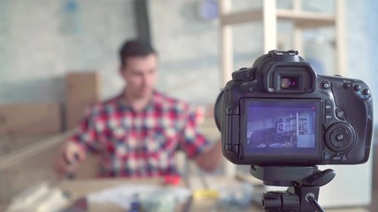 portrait of a male DIY blogger in a workshop, recording a video close up