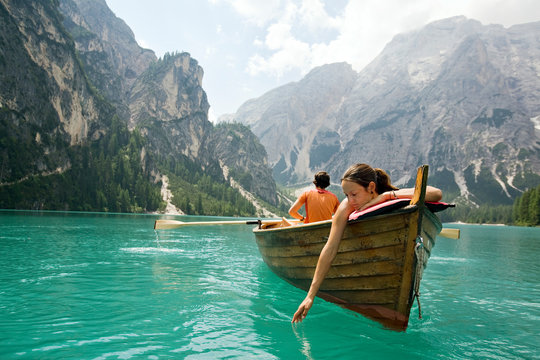 Couple in a row boat on azure Lago di Braies, Italy