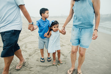 Family Of Four At Foggy Beach And Kids Look Apprehensive