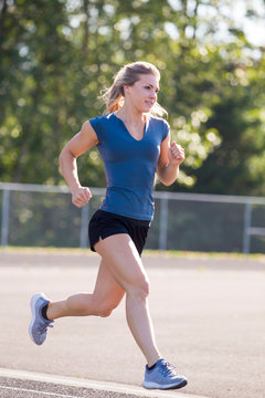 Young woman running on the track