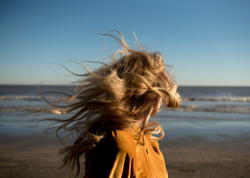 Women on the beach with windblown hair.