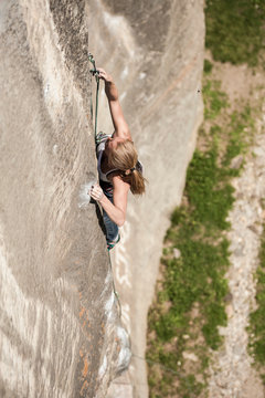 Italian girl climbs a 7a+ route in Balmanolesca, the most historical granite crag in Ossola, Italy.