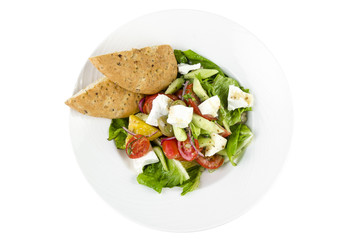 Greek salad with feta cheese, Ligurian olives and tortilla pea and hummus on a plate on a white background, top view isolated