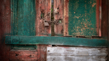 Locked old painted wooden door background. Close up.