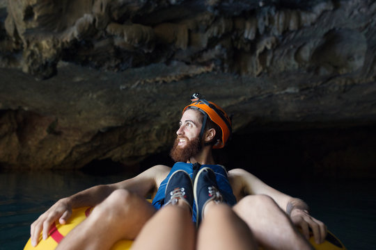 Female view with man river tubbing in a cave