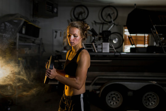 Woman Lifting Weights In Garage