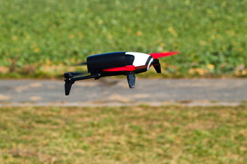 Flying drone with mounted camera in the park