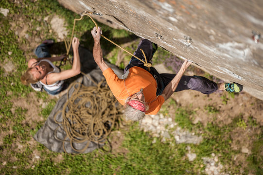 Man climbing Re Azul, an historic 7b route on granite crag of Balmanolesca, Varzo, Italy.