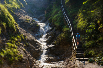 Woman ascending steps near mountain creek