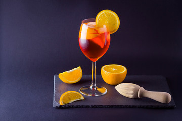 Cocktail aperol spritz on dark background. Summer alcohol cocktail with orange slices. Italian cocktail aperol spritz on slate board. Trendy beverage
