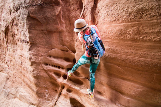 Woman climbing sandstone cliff, Grand Staircase-Escalante National Monument, Utah, USA