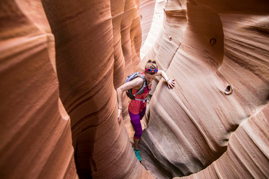 Woman canyoneering through narrow Zebra Canyon, Grand Staircase-Escalante National Monument, Utah, USA