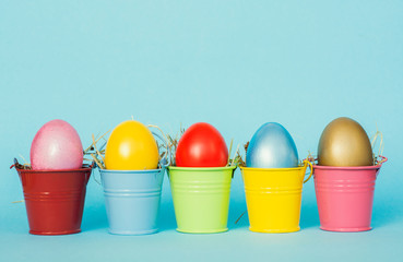 Easter eggs with Rabbit ears in colored buckets, selective focus image, Card Happy Easter