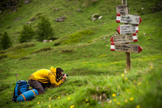 An outdoor photographer thaking photos under the rain in Devero National Park, Ossola, Italy.
