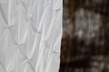 White bed sheets hanging on clothes line to dry
