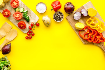 Vegan food cooking with raw vegetables on yellow background top view mock up