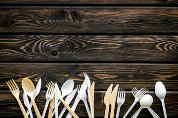 Plastic utilization and the Earth protection concept with flatware on wooden background top view...