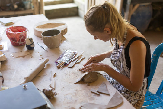 Young woman in ceramic workshop.