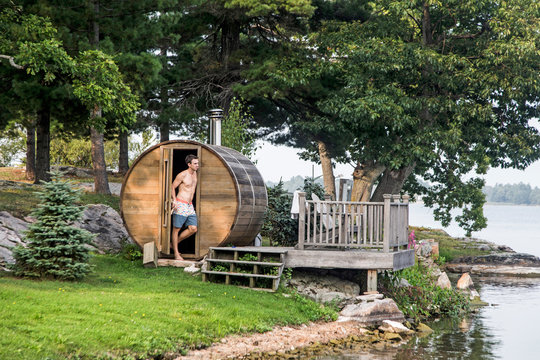 A man stands next to a backyard sauna along the St. Lawrence River in upstate New York's 1000 Islands.