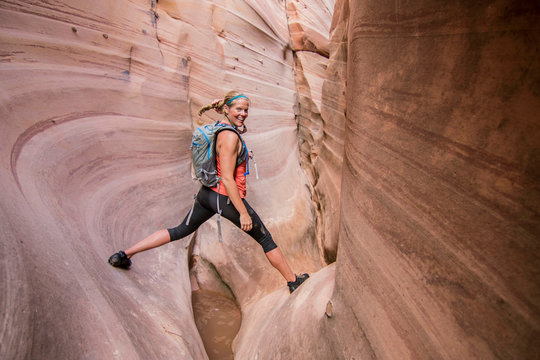 Woman canyoneering through narrow Zebra Canyon, Grand Staircase-Escalante National Monument, Utah, USA
