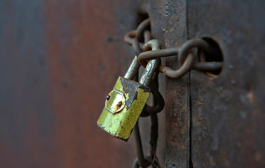 Old metal padlock on a wooden door