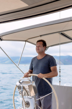 Man standing at helm of boat, Lombok, Indonesia