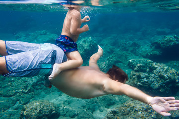 Father and son diving under water,Bali,Indonesia