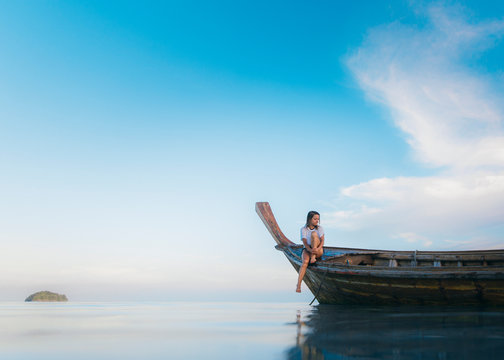 Woman in bikini on prow of longtail boat