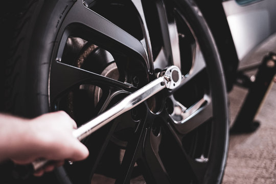 Mechaniker befestigt den Reifen mit einem Drehmomentschlüssel