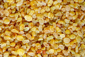 Yellow dry raisins background, close up raisin