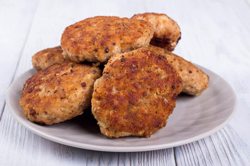 cutlets on a grey plate, on a white wooden background