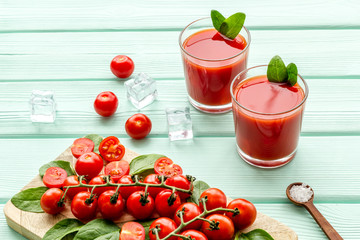 fresh drink with tomato and ice on mint green background