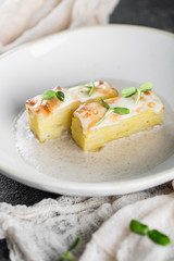 Potato gratin with sauce in a white plate. Restaurant serving
