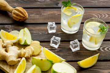 summer cocktails for freshness with apple, orange and ice on wooden background