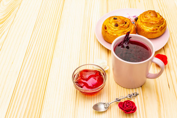 Karkade tea from hibiscus petals (Sudanese rose). Gentle romantic breakfast concept. Buns, meringues, strawberry jelly. On a wooden background, copy space.