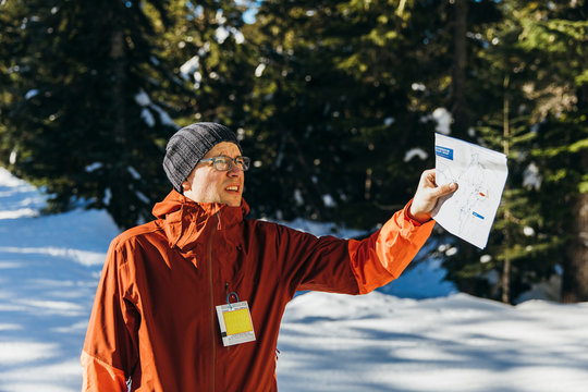 Man holding map while hiking in winter, Whistler, British Columbia, Canada